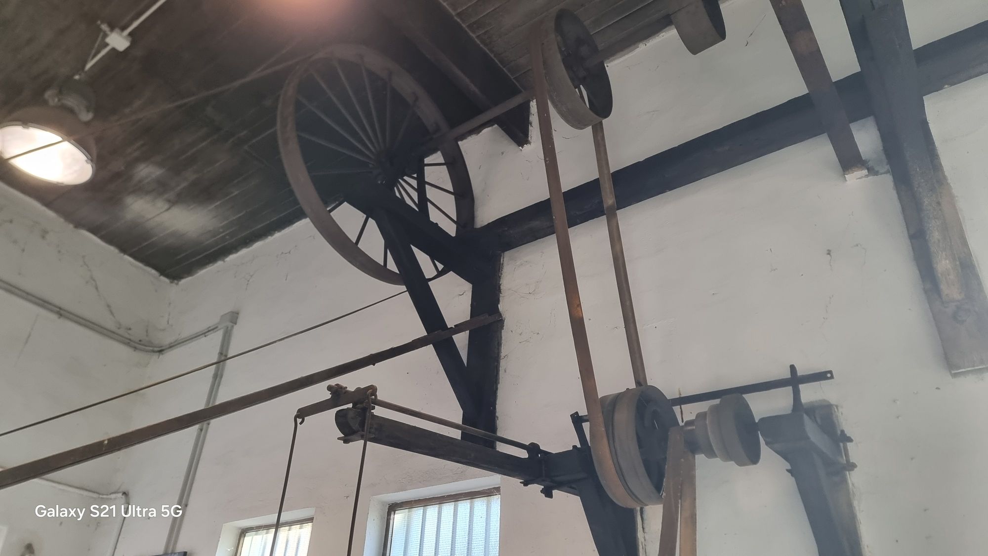 Eje elevado, poleas y correas de la transmisión sobre la nave.