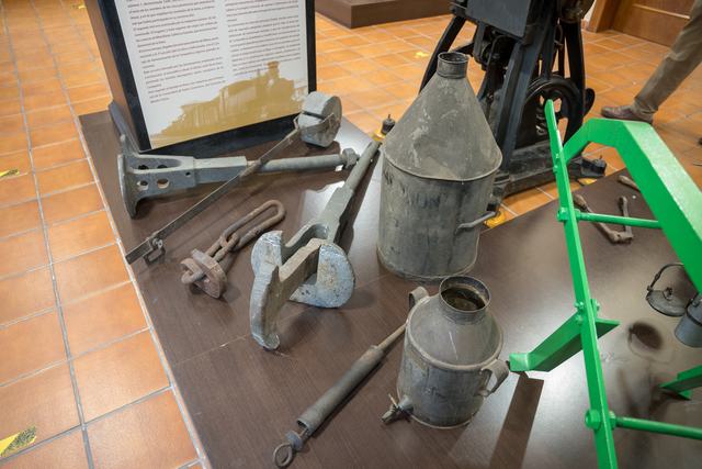 Plano picado de herramientas metálicas largas y de agarre, recipientes de aceite y parte del bastidor verde.